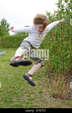 Giovane ragazzo facendo un salto di karate Foto Stock