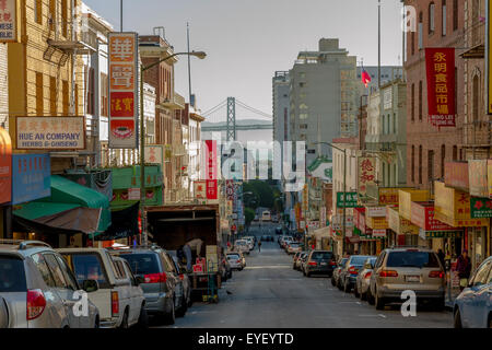 Una vista lungo Washington St nel quartiere Chinatown di San Francisco, con l'Oakland Bay Bridge in lontananza, San Francisco California Foto Stock