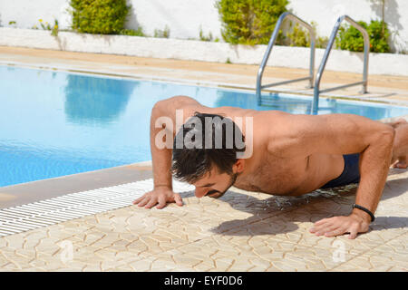 Barbuto conciate uomo esercitare presso la piscina Foto Stock