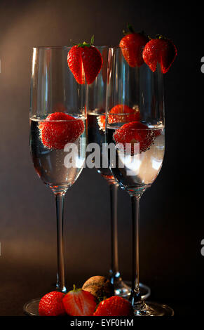 Tre bicchieri di champagne cocktail contro uno sfondo scuro Foto Stock