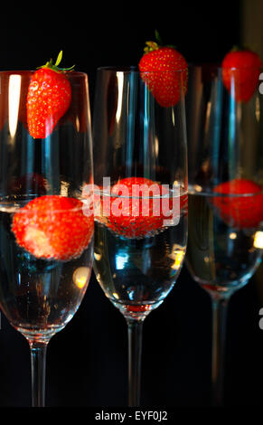 Tre bicchieri di champagne cocktail contro un sfondo nero Foto Stock