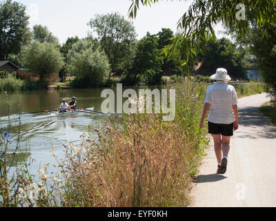 I canottieri sul Fiume Tamigi e un pedone on Thames Path; Oxford, Inghilterra Foto Stock