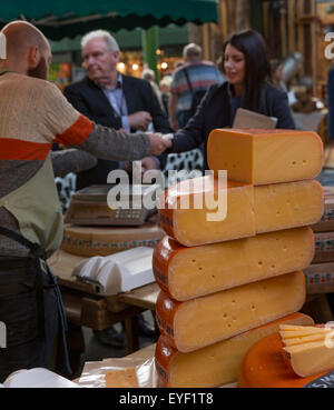 Formaggio di fornitori e clienti in una fase di stallo nel mercato di Borough, Londra Foto Stock