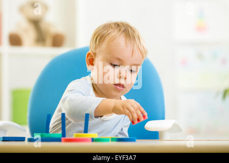 Capretto piccolo ragazzo giocando con dei giocattoli educativi Foto Stock