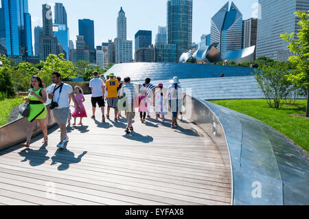 Le persone che attraversano il ponte di BP in Chicago, progettato da Frank Gehry. Foto Stock