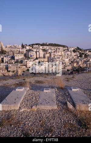 Vista delle antiche Tombe Ebraiche e del quartiere palestinese di Silwan o Siloam attraverso la collina in Gerusalemme Est Israele Foto Stock