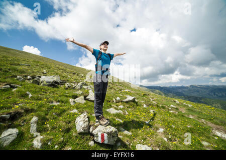 Ragazzo adolescente escursionista godendo della libertà sulla cima delle montagne Foto Stock