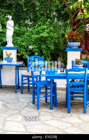 Tradizionale greco blu sedie in un bellissimo cortile Foto Stock