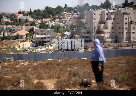 Luglio 28, 2015 - Ramallah, West Bank, Territorio palestinese - Una donna Palestinese, orologi israeliano di macchinari pesanti come essi demolire vacante blocchi di appartamenti per ordine di Israele la High Court, in Cisgiordania insediamento ebraico di Beit El vicino a Ramallah Luglio 29, 2015. Israele ha dato l'approvazione finale il mercoledì per i piani per la costruzione di 300 nuove case nell'insediamento ebraico nella Cisgiordania occupata, annunciando la mossa in quanto ha effettuato una corte ordine di demolizione contro due vacante blocchi appartamento presso il sito. Decine di coloni Ebrei hanno raccolto negli ultimi giorni a Beit El settlement per protestare ag Foto Stock