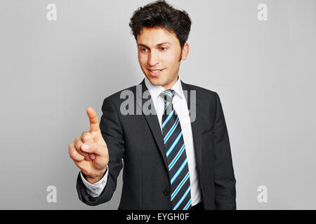 Business man spingendo con il suo dito indice su una interfaccia virtuale Foto Stock