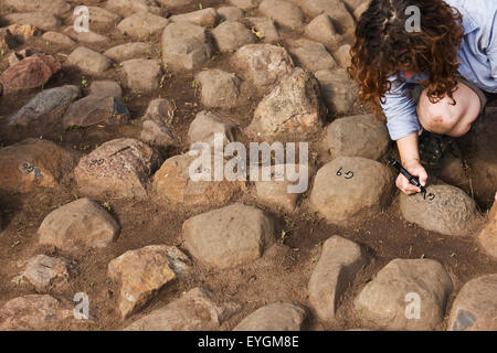 Sud ovest dell Etiopia, Valle dell'Omo, Mursiland meridionale, Donna la scrittura dei numeri delle pietre di prima benna kulugto; Dirikoro Foto Stock