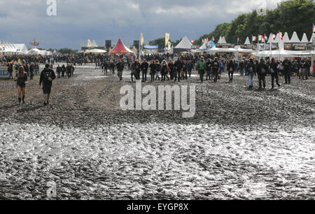 Wacken, Germania. 29 Luglio, 2015. I visitatori del W.O.A. (Wacken Open Air) a piedi attraverso il fango sul sito del festival in Wacken, Germania, 29 luglio 2015. Heavy Metal tifosi provenienti da tutto il mondo vengono a Wacken per celebrare il più grande del mondo di heavy metal festival. Credito: dpa picture alliance/Alamy Live News Foto Stock