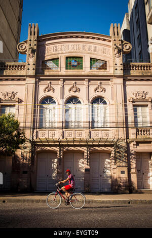 Il Brasile, Rio Grande do Sul, adolescente in bici nella parte anteriore del Theatro Sete de Abril in quartiere residenziale; Pelotas Foto Stock