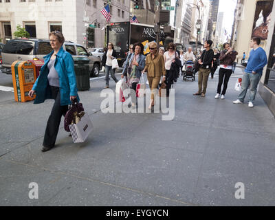 Persone che passeggiano giù Fifth Avenue vicino al West 57th Street in Manhattan. Foto Stock