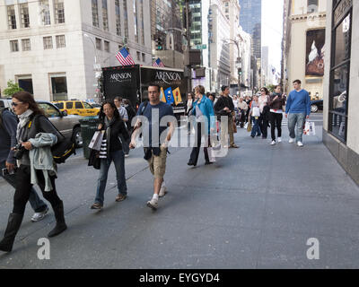 Persone che passeggiano giù Fifth Avenue vicino al West 57th Street in Manhattan. Foto Stock