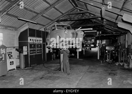 Cardiff 1960; garage interno con meccanico Foto Stock
