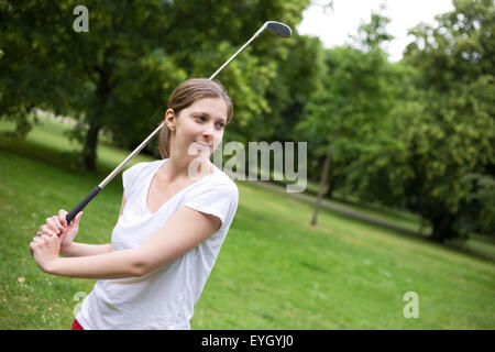 Giovane donna giocando a golf Foto Stock