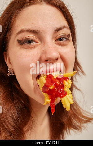 Divertimento donna mangia le patatine fritte Foto Stock