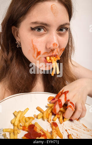 Divertimento donna mangia le patatine fritte Foto Stock