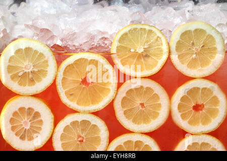 Limoni freschi galleggianti in limonata rosa Foto Stock