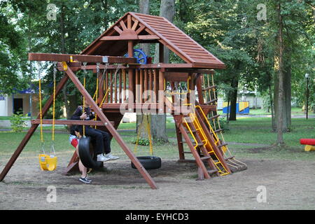 Bellissimo, accogliente e comodo parco giochi con scivolo, altalena e scale in estate il parco della città Foto Stock