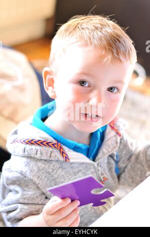 Ritratto di un bambino con o puzzle jigsaw Foto Stock