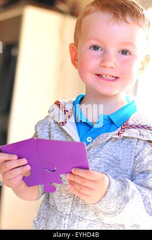 Ritratto di un bambino con o puzzle jigsaw Foto Stock