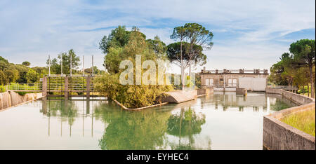 Installazione delle serrature sul fiume per deviare l'acqua in vari canali di irrigazione per l'agricoltura Foto Stock