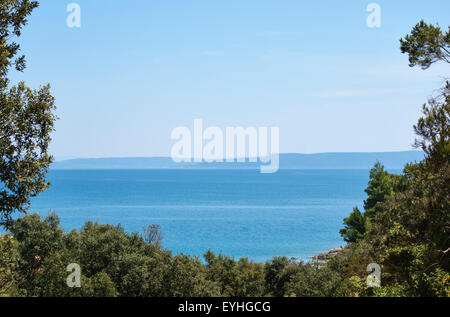 Istria, Croazia. Una vista da Duga Uvala attraverso l'Adriatico verso la lontana isola di Cherso nel Golfo di Quarnero Foto Stock