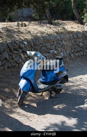 Scooter blu parcheggiato su una strada sterrata a Maiorca, isole Baleari, Spagna nel mese di luglio. Foto Stock