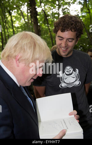 Shooters Hill, Londra, Regno Unito. Il 30 luglio, 2015. Sindaco di Londra Boris Johnson, segni un libro come egli visiti new kids' Adventure Centre in Shooters Hill come Team Londra hits 100.000 volontari. Credito: Keith Larby/Alamy Live News Foto Stock