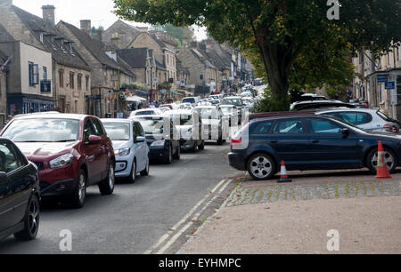 Honeypot Tourist Village street affollata con il traffico a Burford, Oxfordshire, England, Regno Unito Foto Stock