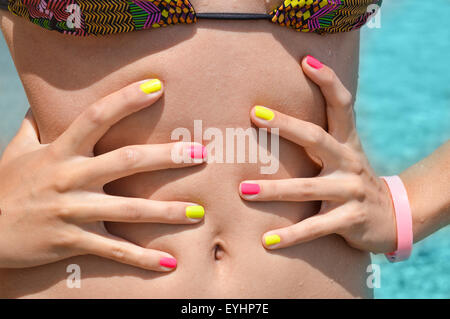 Ragazza in Bikini misurando in vita con le sue mani al mare Foto Stock