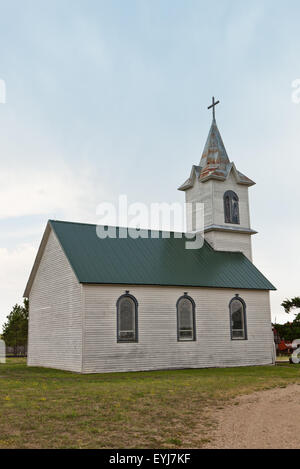 Una vecchia chiesa della prateria con vernice sbiadita e un arrugginito steeple in Sud Dakota Foto Stock