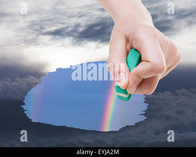 Meteo concetto - lato elimina nuvole temporalesche su sky da gomma eraser da immagine e rainbow appaiono Foto Stock