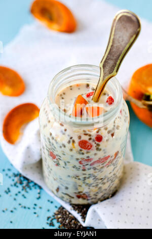 Budino di Chia con persimmon e bacche di goji servita in un vasetto di vetro Foto Stock