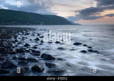 Tramonto sulla spiaggia Bossington con Porlock Weir e le colline di Exmoor in distanza. Foto Stock