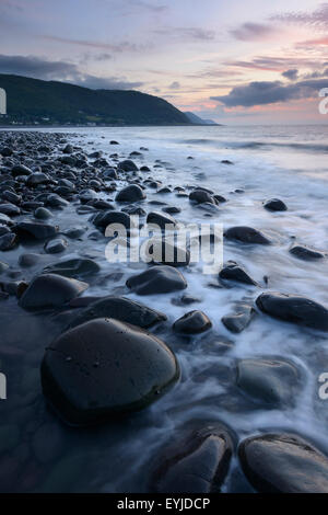 Tramonto sulla spiaggia Bossington con Porlock Weir e le colline di Exmoor in distanza. Foto Stock