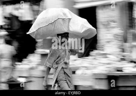 Uomo che trasportano il sacco sulla testa rangoon brian mcguire Foto Stock