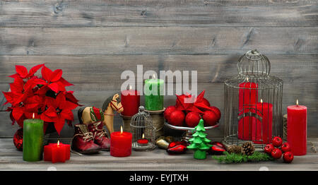 Vintage decorazioni di Natale con candele rosse, fiore poinsettia, stelle e baubles. Foto Stock