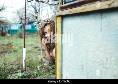 Bella ragazza a spiare qualcuno Foto Stock