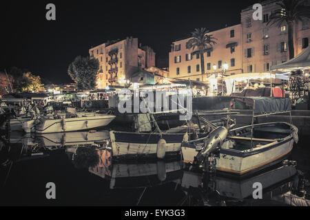 Legno di piccole barche da pesca ormeggiate nel porto di Ajaccio, Corsica, Francia. Vintage tonica notte foto con il vecchio filtro di stile Foto Stock