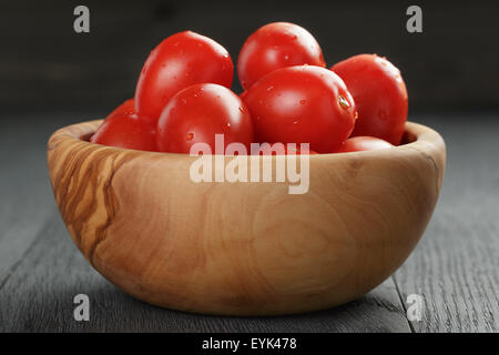 Red Cherry Plum pomodori in vaso di olive su tavola di legno Foto Stock