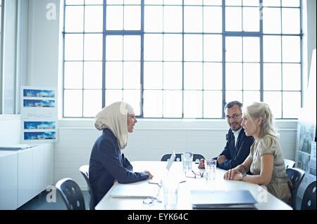 Due imprenditrici e uomo chat a un tavolo per conferenza Foto Stock