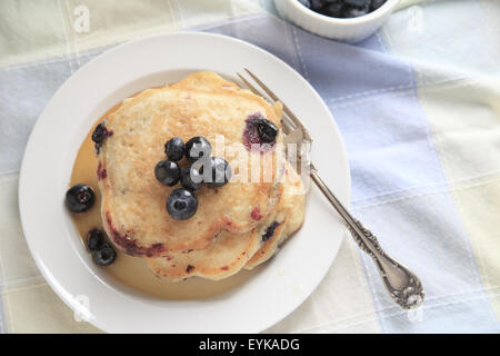 Appena sfornati pancake con mirtilli e sciroppo su una piastra con la forcella, copia spazio compreso Foto Stock