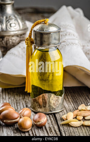 Bottiglia di olio di argan con noci e semi. Foto Stock