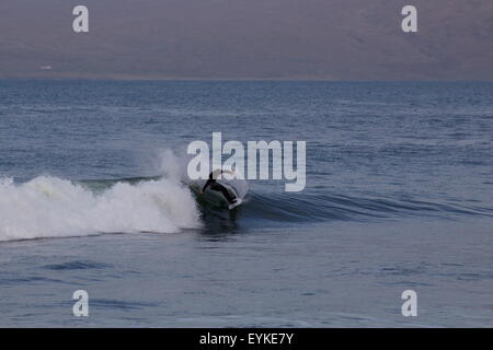 Winterman : un inverno lone Surfer nel freddo invernale in Irlanda. Foto Stock