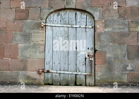 Vecchio, weathered blue porta in legno con cerniere arrugginite, Germania. Foto Stock