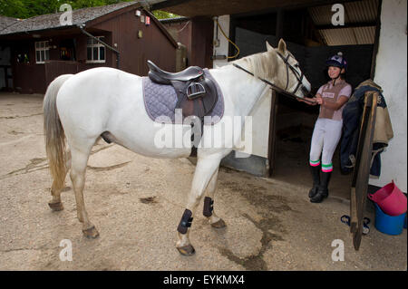 Ella Manning formazione il suo cavallo "Turner' in un arena showjumping,assistita da sua madre Victoria.Un REGNO UNITO salta in sella"white horse" Foto Stock