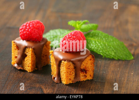 Morso dimensioni gingerbread piazze con liquido di cioccolato e lamponi freschi sulla parte superiore Foto Stock